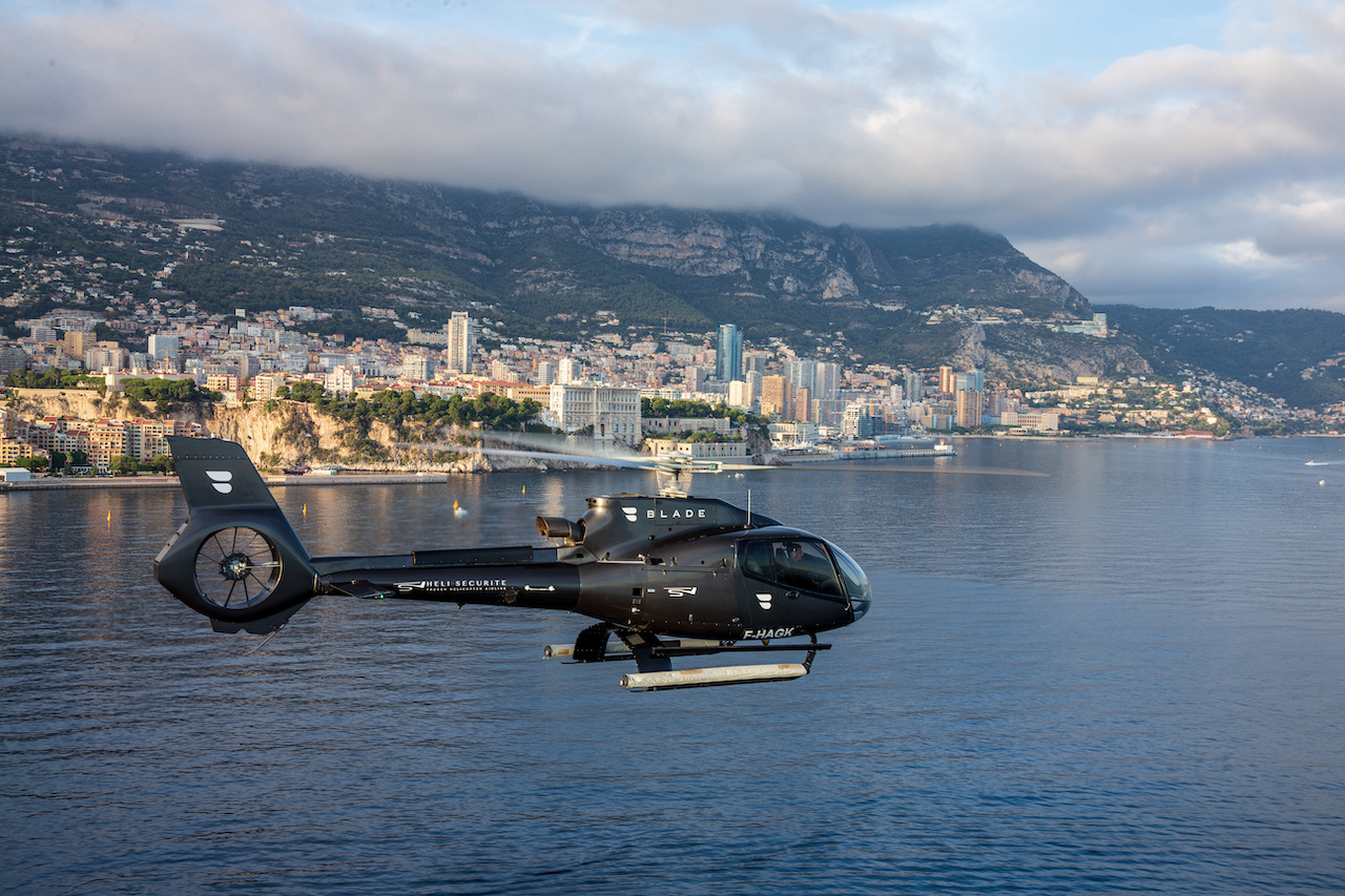 Black helicopter over the Monaco coastline.